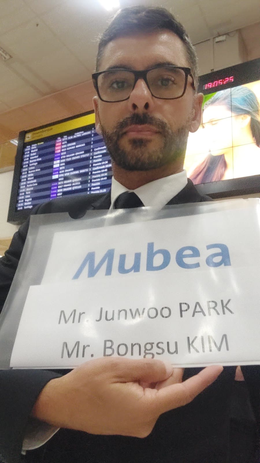 Motorista do Táxi do Vale recebendo clientes no aeroporto com placa